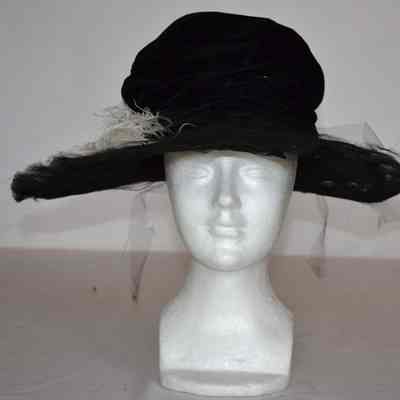 Velvet slouch crown with wired brim covered in lace and netting with large white plume