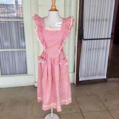 Pink pinafore dress with white eyelet lace trim and front pockets
