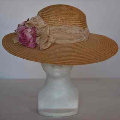 Wide brimmed straw hat with lace hat band and faux flowers