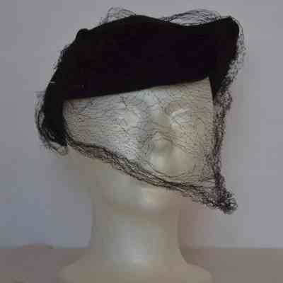 Felt form fitting hat with turned up short brim, black velvet bow, beaded braid adornment and veiling
