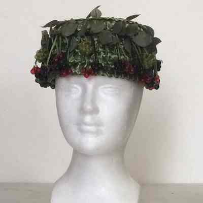 Pillbox in green straw with black, green and red currants and leaves, green velvet bow in back