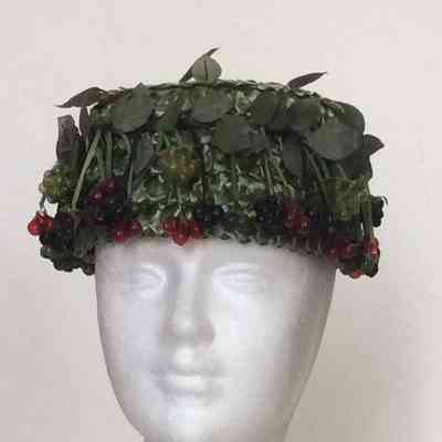 Pillbox in green straw with black, green and red currants and leaves, green velvet bow in back
