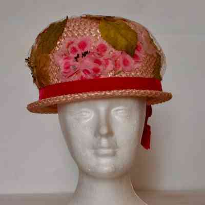 Straw bubble hat with narrow brim, crown covered with floweres and Russian veiling, pink velvet hat band.