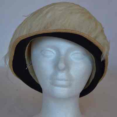 Straw cloche style hat with black satin trim on narrow brim and feather covered crown