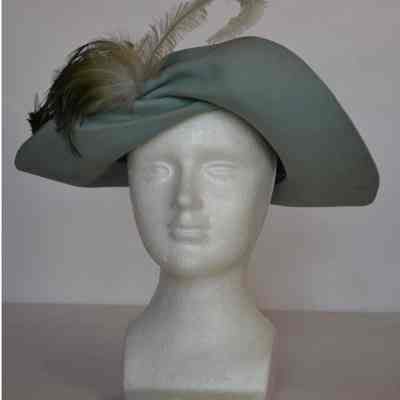 Felt twist front brim hat with green feathers