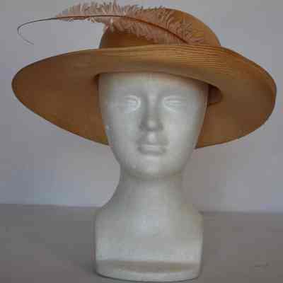 Straw wide brimmed hat with pink feather and snakeskin band