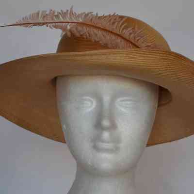 Straw wide brimmed hat with pink feather and snakeskin band