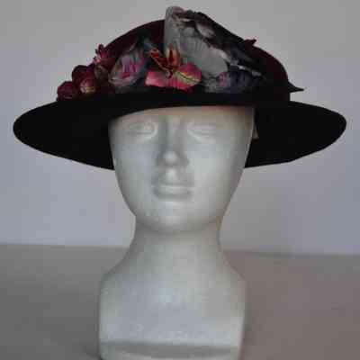 Dark red crown with black brim and cluster of faux flowers