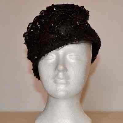 Toque of black netting adorned with black lace and sequins