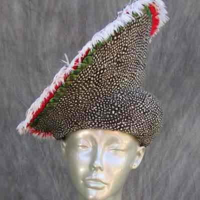 Black and white feathered hat with red and green trim and white feather edging
