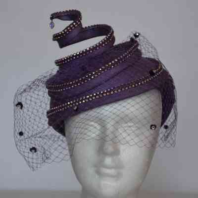 Straw cocktail hat with crystal embellished corkscrew element and crystal dotted netting