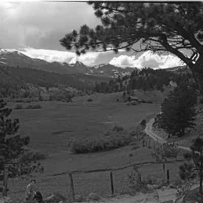 Continental Divide west from Range view, N.E. of Ward, June 1946, shows road, fence, buildings, and person in foreground who may be Lois Kemp