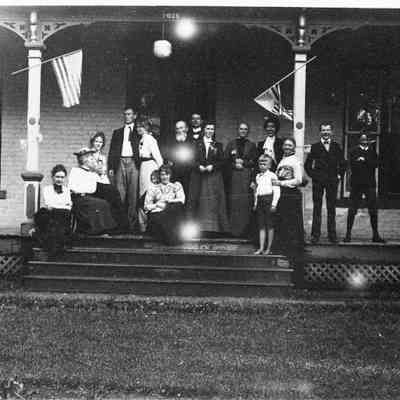 2b. Large group of people on porch, identified as Mrs. Phillip Kaiser, Mrs. S.C. Barrett (Aunt Barrett), Miss Elizabeth Barrett, Darsie C. Bard, Mrs. Bessie Bard (Darsie's mother), Mrs. John H. Kemp (seated, front), Robert A. Kemp (yungest son), James Alex ander Campbell, Dr. Phillip Kaiser, Miss McGilvery, Mr. -- Kaiser (father of Phillip), Miss McGilvery, David D. Barrett (standing, front), Mrs. Kaiser (mother of Phillip), James W. Barrett, Donald C. Kemp.: Negative in Envelope 2, also 5"x7" print