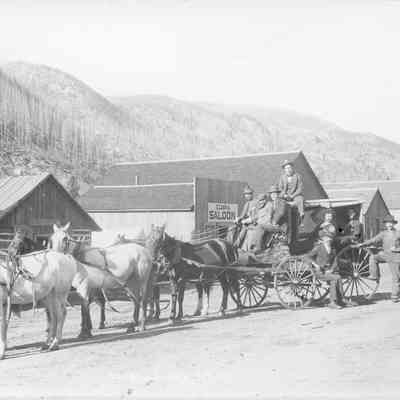 6. Talmage & Lilly Eldora, Nederland & Caribou stage.: Stage is pulled by a six-horse team. One man stands at left with a rifle over his shoulder. Three men sit on front seat of the coach, one man sits on top, two inside, and one man on the running board. Three more men stand on the right (one partially obscured). Businesses shown are The Eldora Meat Market, Board & Lodging, and Eldora Saloon. 5"x7" print. Inscribed on bottom: Sturdevant MRP, Eldora Stage No. 110
