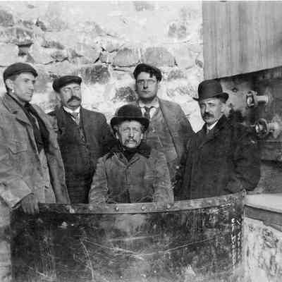 7. Group of men, possibly investors, standing in bucket with shipping instructions to Wano via Boulder: 8.5"x11" print and digital