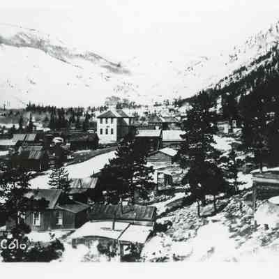 Photo 4: Big white building is schoolhouse. May be early 1900s. Photo postcard.