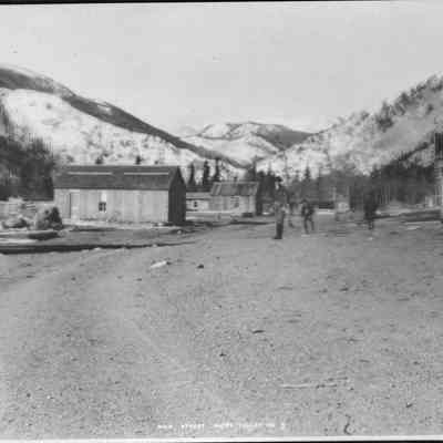 3. Happy Valley Main Street No. 2: Five people stand in the street, several frame buildings. 5"x7" negative