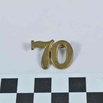 Stamped brass hat insignia "70"
