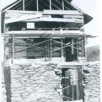 Exterior view of farmhouse with exposed wood and stone