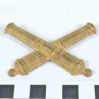 Stamped brass U.S. 1860 officer's artillery crossed-cannon hat badge
