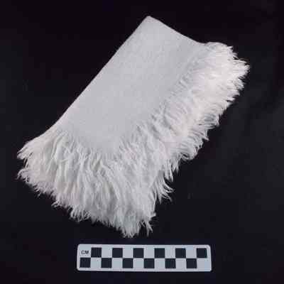 Six white linen napkins with fringe