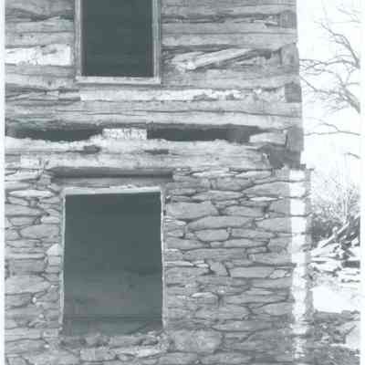 Exterior corner of farmhouse with exposed wood and stone