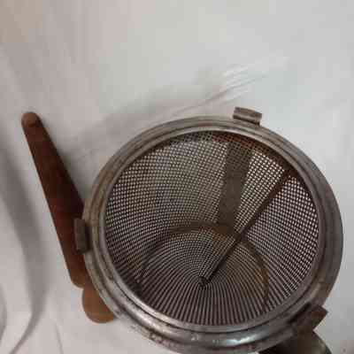 Metal strainer with wooden pestle