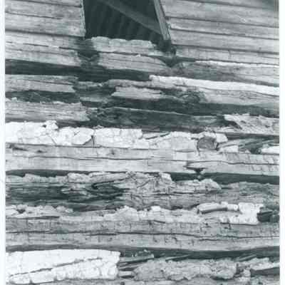 Exterior of farmhouse showing exposed wood and one window