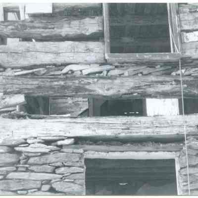 Close-up view of exterior of farmhouse showing wood and stone