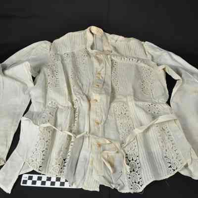 White blouse with embroidered design on front with holes