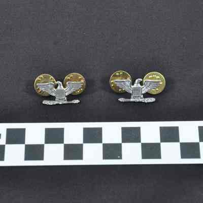 Set of eagle pins worn on a U.S. Navy khaki uniform