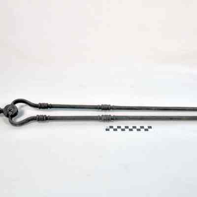 Heavy metal fireplace tongs with large round handle on top