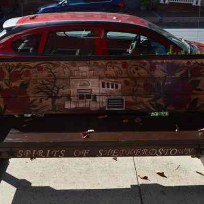 Bench with paintings of Shepherdstown Public Library and ghosts