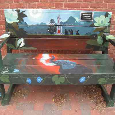 Bench with paintings of Trinity Episcopal Church, people, elephant (IMG3820007)