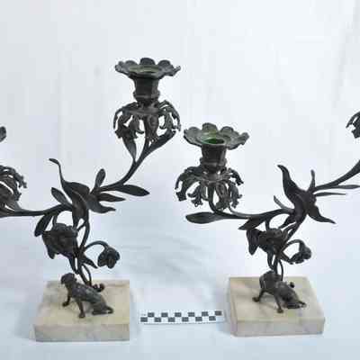 Two cast iron, brass, bronze and marble candlesticks