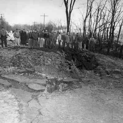 Halltown dynamite truck explosion - citizens at edge of crater in road