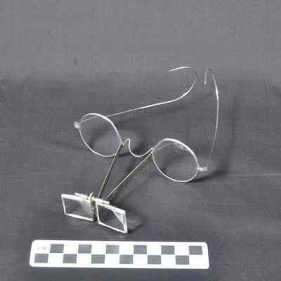 Wire rimmed eyeglasses with magnifying extension attached to bridge