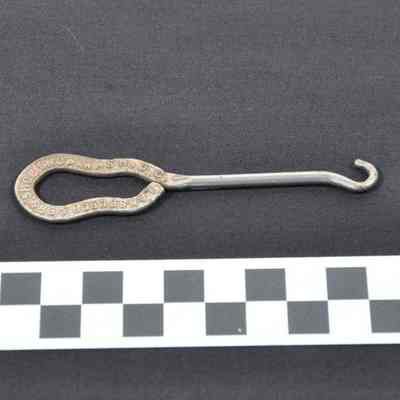 Metal (silver-colored) buttonhook with flat, open handle