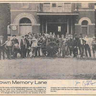 Individuals in front of hose reel in front of Independent Fire Company, CT