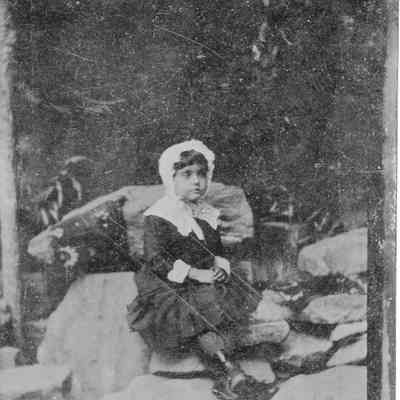 Young woman in a bonnet sitting on rocks