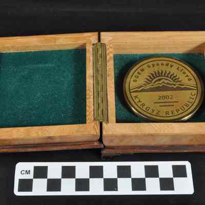 Bronze colored medal or coin in wooden presentation box