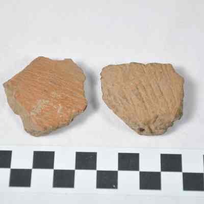 Two red-orange colored pieces of brick or pottery