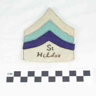 Three chevrons sewn on faded light tan felt