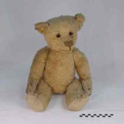 Bear has light tan cotton fur, black button eyes