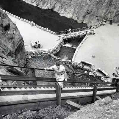Wooden steps near rocks and water. Likely a tourist destination.