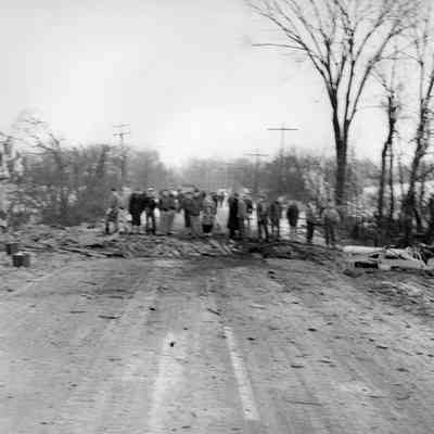 Halltown dynamite truck explosion - citizens at edge of crater in road