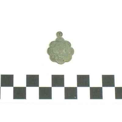 Round silver medallion with scalloped edges