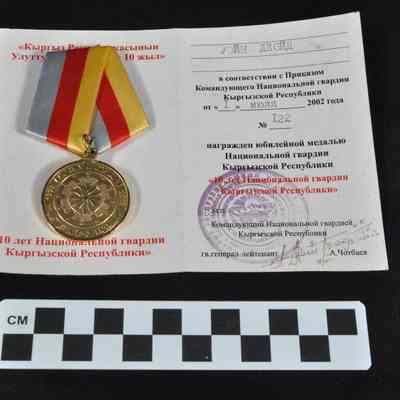 Gold colored medal with Cyrillic writing on both sides