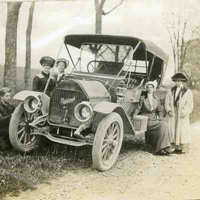 Four women and a man in a car