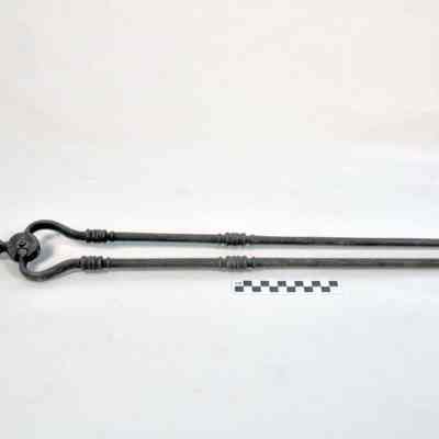 Heavy metal fireplace tongs with large round handle on top